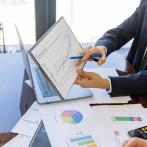 Business professionals discussing financial graphs and charts in an office setting.